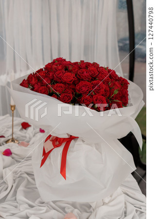 Luxurious Red Rose Bouquet: A Heartfelt Gesture of Romance, 100 Roses Wrapped in White Paper with Ribbons, Valentine's Day, Love, Floral Arrangement. 127440798