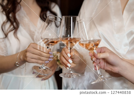 Celebrating Friendship: Women Toasting Rose Wine in Matching Robes, Close-up, Warm Lighting, Bridal Party, Luxury, Joyful, Pink Tones Celebrating Friendship: Women Toasting Rose Wine in Matching Robes, Close-up, Warm Lighting, Bridal Party, Luxury, Joyful, Pink Tones 127440838