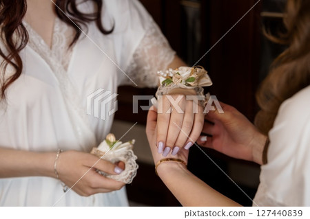 Bridesmaids Getting Ready, Corsage Pinning Ceremony, Ivory Robes, Wedding Preparation, Pearl Details, Soft Lighting, Elegant Style. Bridesmaids Getting Ready, Corsage Pinning Ceremony, Ivory Robes, Wedding Preparation, Pearl Details, Soft Lighting, Elegant Style. 127440839
