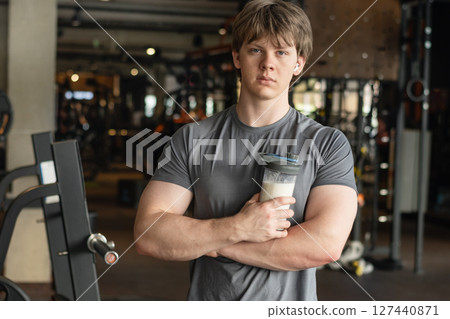 Portrait of sporty caucasian healthy fitness man with protein shake. Athlete and professional trainer with sports nutrition beverage while working out. Health care and workout. 127440871