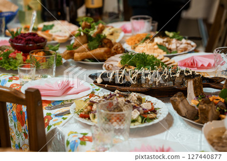 Lavishly Set Traditional Feast Table: Abundant Ukrainian Cuisine, Colorful Dishes, Festive Dinner, Family Gathering, Dark Wood, Vibrant Textiles. 127440877