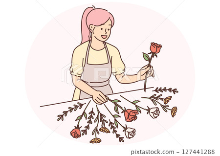 Woman florist stands near table with flowers collecting beautiful bouquet for wedding gift to bride 127441288