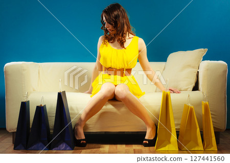 Woman with shopping bags on couch Woman with shopping bags on couch 127441560