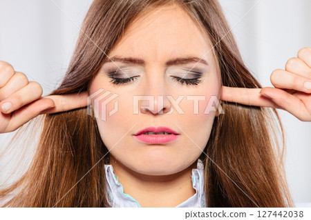 Stressed woman with closed eyes put fingers in ears, Stressed woman with closed eyes put fingers in ears, 127442038