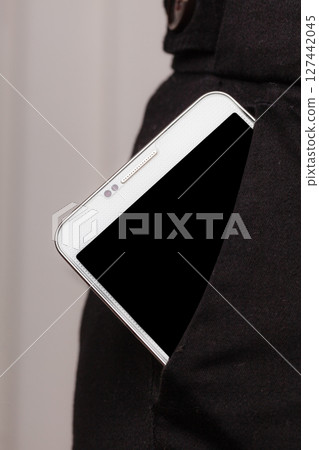 Mobile phone in trousers pocket showing. Mobile phone in trousers pocket showing. 127442045