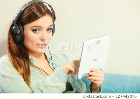 Woman with tablet headphones relaxing 127442076