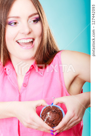 Smiling woman holds chocolate cake in hand Smiling woman holds chocolate cake in hand 127442093