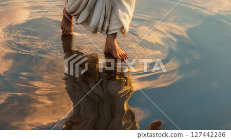 Jesus walks on water at sunset with feet gently touching the surface, creating ripples 127442286