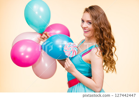 Woman with colorful balloons and lollipop 127442447