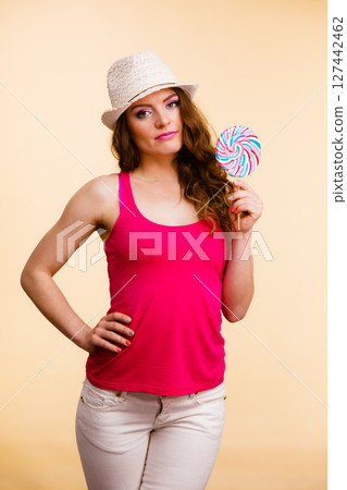 Woman holds colorful lollipop candy in hand Woman holds colorful lollipop candy in hand 127442462