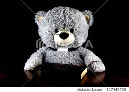 Teddy Bear Dressed as Catholic Priest with Bible and Rosary on a Black Background Teddy Bear Dressed as Catholic Priest with Bible and Rosary on a Black Background 127442786