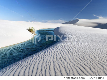 Under the blue sky, water springs from the white desert. An image of dryness and moisture. 127443051