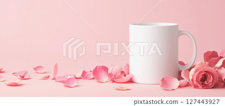 white ceramic mug surrounded by elegant rose petals on soft pink background, creating serene and romantic atmosphere 127443927