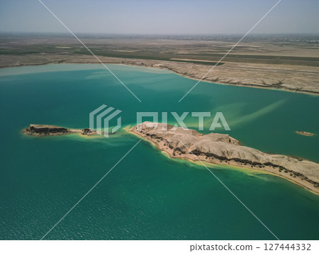 Aerial: elongated desert island in Kuimazar Reservoir, Uzbekistan 127444332