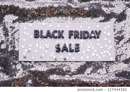 BLACK FRIDAY SALE sign on a sparkling silver sequin background. 127444382