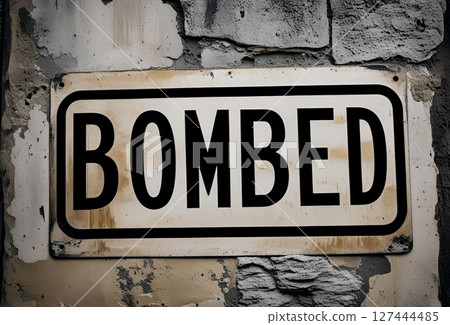 A sign saying bombed on a dirty wall 127444485