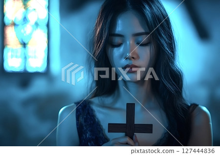 Asian woman praying with cross in church at night 127444836
