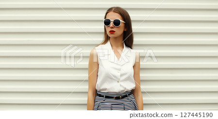 Fashion portrait of stylish young woman model, modern girl posing on white wall background 127445190