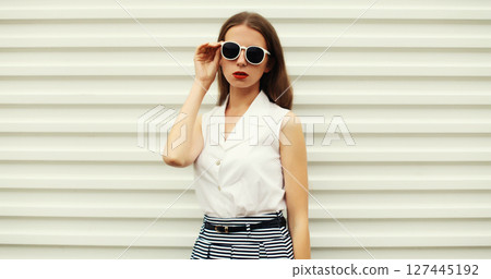 Fashion portrait of stylish young woman model, modern girl posing on white wall background 127445192