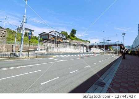 A large deserted intersection with traffic lights and signposts on a sunny day A large deserted intersection with traffic lights and signposts on a sunny day 127445427