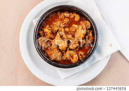 Stewed chicken gizzards in a sauce in a bowl on the table. Top view. Typical Spanish appetizer 127445659