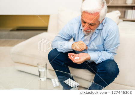 Middle aged senior man with medical pill and glass of water. Mature old senior grandfather taking medication cure pills vitamin. Age prescription medicine healthcare therapy concept Middle aged senior man with medical pill and glass of water. Mature old senior grandfather taking medication cure pills vitamin. Age prescription medicine healthcare therapy concept 127446368
