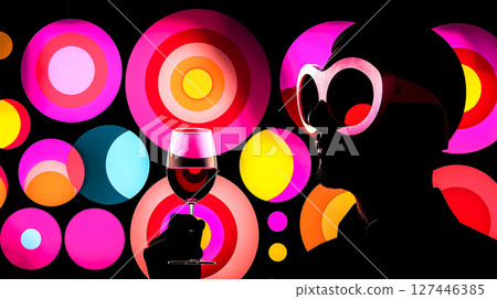 A man holding a glass of wine in front of a colorful background 127446385