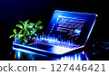 A laptop computer sitting on top of a desk next to a plant 127446421