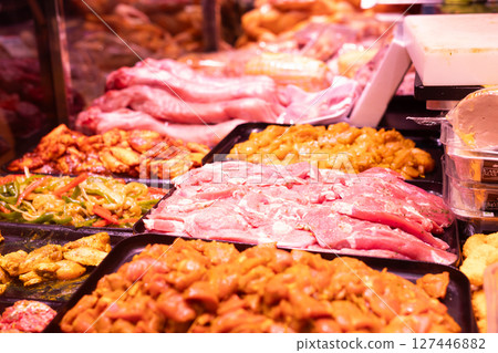 Different types of marinated meat and vegetables on display at grocery supermarket 127446882