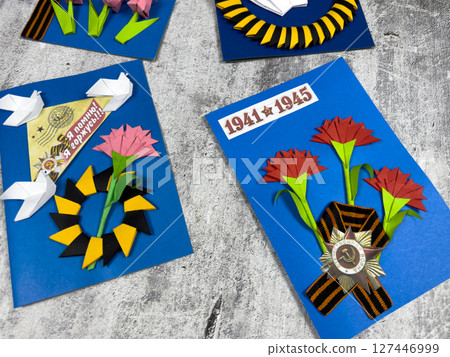 Victory Day cards with iconic Soviet symbols: red carnations, the Saint George ribbon, and the 1941-1945 war date. Handmade tribute to remembrance and peace 127446999