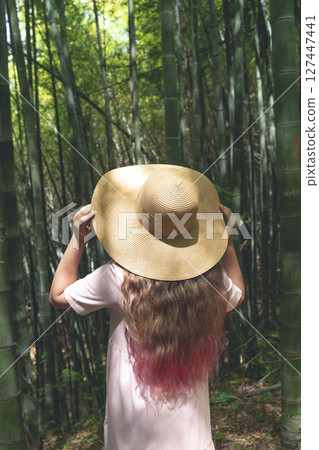 Girl in Straw Hat Exploring Bamboo Forest in Asia Girl in Straw Hat Exploring Bamboo Forest in Asia 127447441
