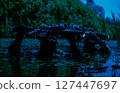Two armed soldiers in camouflage, carrying rifles above water, wade slowly through a dense, swamp-like area surrounded by greenery. 127447697