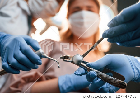 First person view. Three doctors are working. In the stomatological cabinet 127447713
