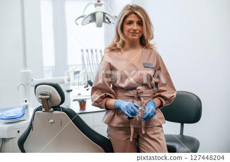 Beautiful woman doctor is sitting. In the stomatological cabinet Beautiful woman doctor is sitting. In the stomatological cabinet 127448204