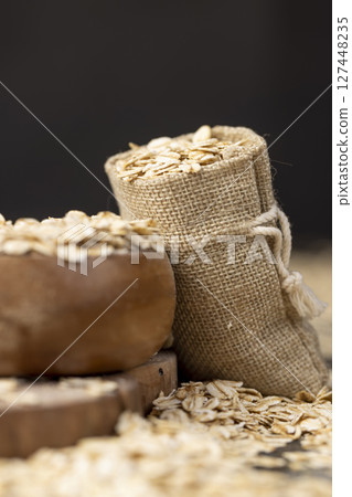 bag with oatmeal flakes, scattered dry cereal flakes from oats, flattened, steamed and dried, side view bag with oatmeal flakes, scattered dry cereal flakes from oats, flattened, steamed and dried, side view 127448235
