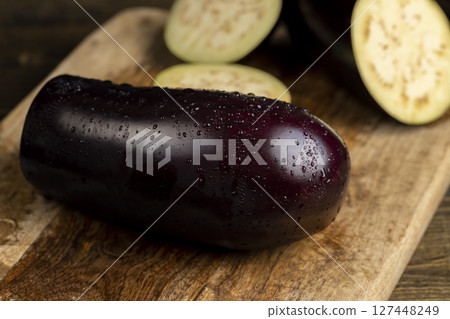 eggplant sliced across with seeds inside close up, ripe purple delicious eggplant sliced across the fruit on the kitchen table 127448249
