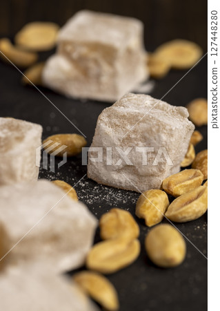 Turkish delight in powdered sugar with nuts inside, oriental sweets Turkish delight with peanuts on a slate board, side view Turkish delight in powdered sugar with nuts inside, oriental sweets Turkish delight with peanuts on a slate board, side view 127448280