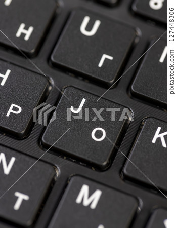 black computer keyboard with English and Russian letters closeup, details of the black keyboard in the layout of letters in several languages 127448306