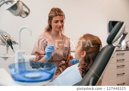 Female doctor is working with little girl. In the stomatological cabinet Female doctor is working with little girl. In the stomatological cabinet 127448325