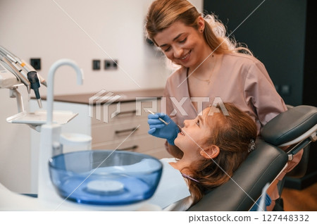 Woman is working with little girl teeth. In the stomatological cabinet Woman is working with little girl teeth. In the stomatological cabinet 127448332