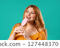 Body positive woman Singing, Dancing With Hair Brush Instead Microphone On Blue  127448370