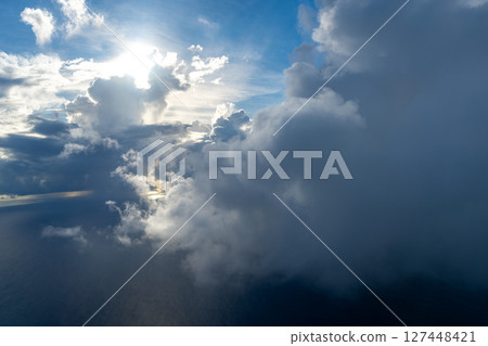 Dramatic sky with sunbeams and clouds seen from an airplane 127448421