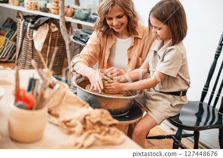 Clay modeling. Mother with little girl doing pottery at home 127448676