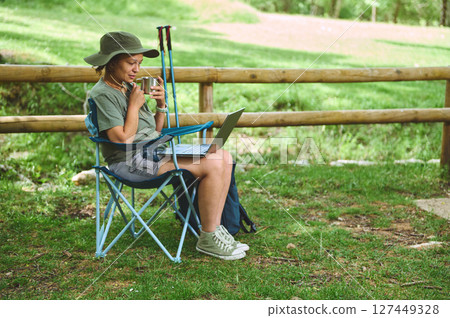 Woman Working Remotely Outdoors with Laptop in Nature 127449328