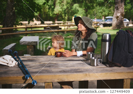 Mother and Child Enjoying Nature at a Picnic Table in a Forest Campground Mother and Child Enjoying Nature at a Picnic Table in a Forest Campground 127449409