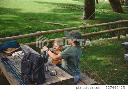Mother and Child Enjoying a Lunch Break in a Serene Outdoor Setting 127449425