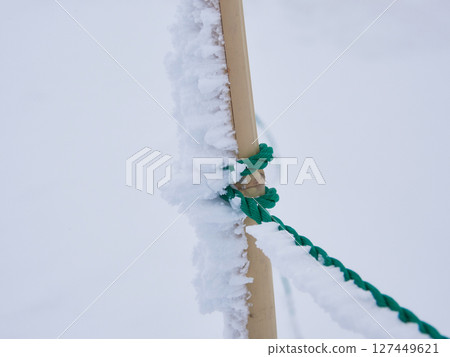 Frozen snow landscape on bamboo and rope outdoors in harsh winter cold 127449621