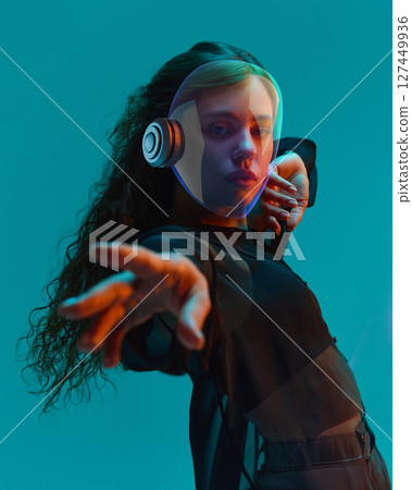 Futuristic 3D helmeted woman reaching out under teal light. Youth culture concept 127449936
