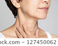 Image of a woman in her 50s checking wrinkles on her neck 127450062