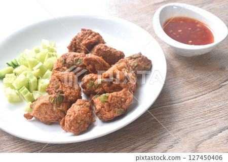 deep fried grouper fish patty on plate with slice cucumber dipping sweet chili sauce  127450406